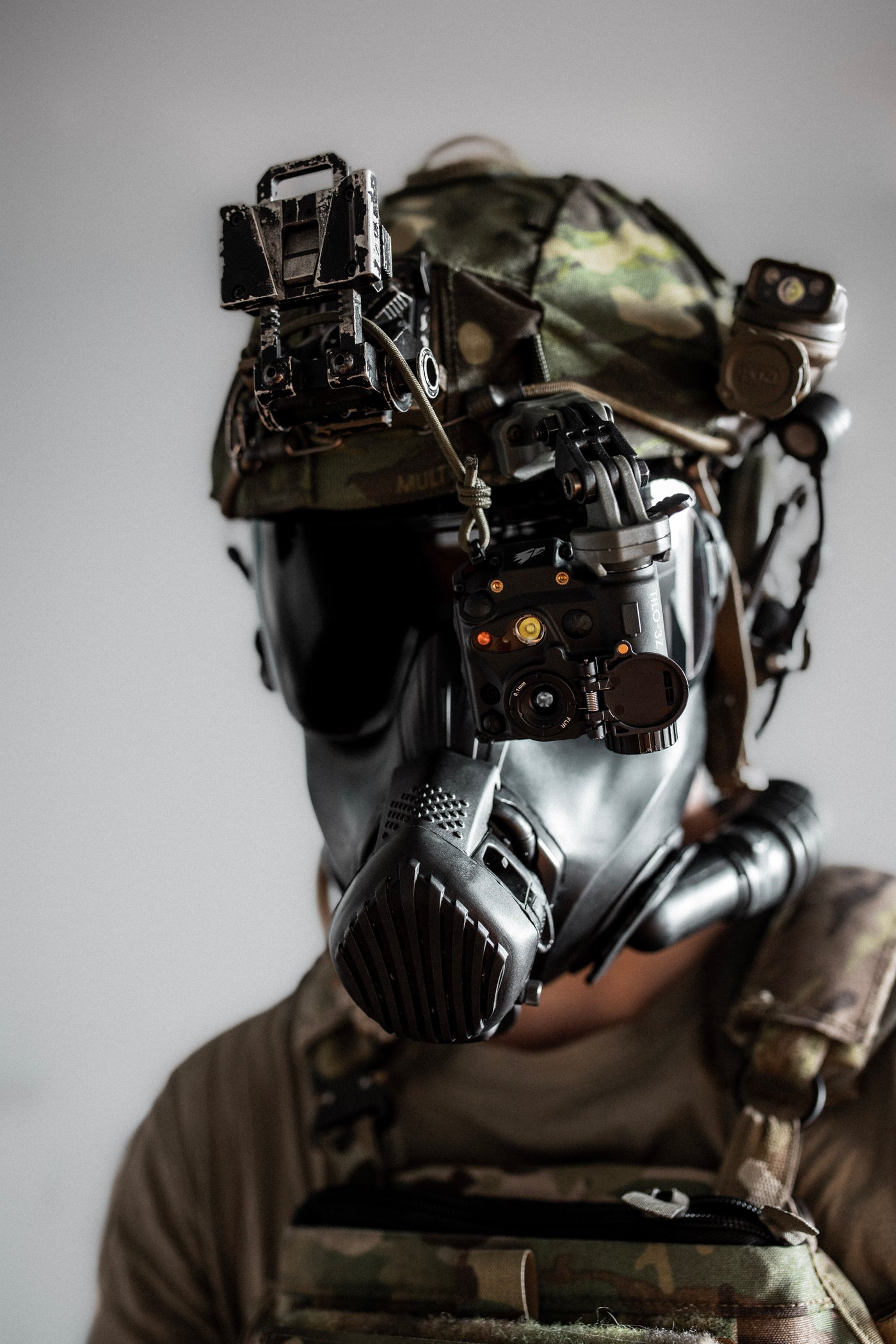 Portrait einer Person mit militärischer Ausrüstung, einer Gasmaske und einer TILO befestigt am Helm.